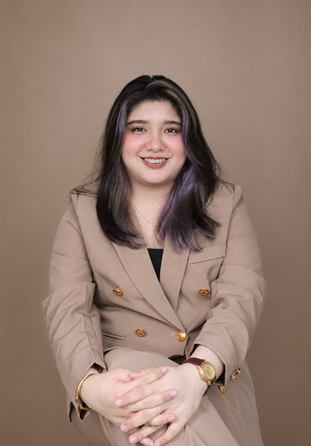 Angela Alvarez smiling in a brown suit